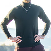Man wearing a black Merino Turtleneck with a blurred natural background