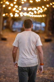 Man walking away from the camera with string lights in the background