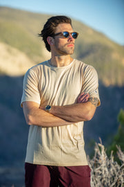 Man wearing sunglasses and a Silk Cashmere Merino T-Shirt with mountains in the background